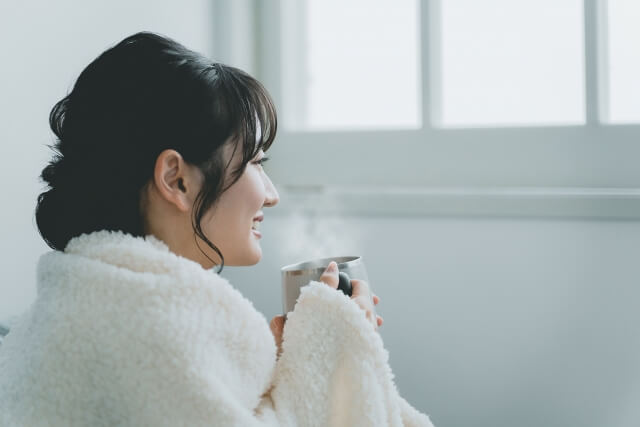 温かい飲み物を飲む女性